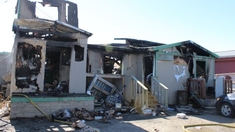 Fire hoses remain outside the burned-out remains of Kotzebue's Uutuku restaurant on June 3, 2026. The fire, ruled undetermined by investigators, destroyed the roughly 5,000-square-foot building.