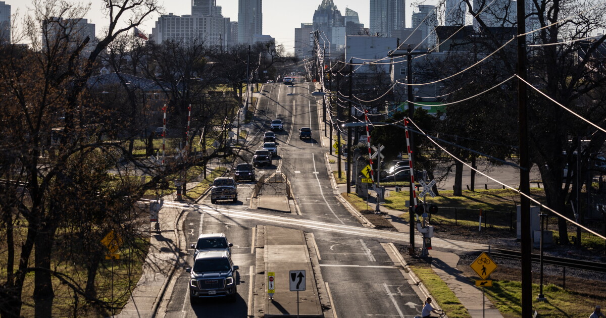 Backlit cars driving down a road