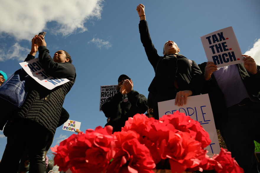 FILE: Rally-goers chant outside the Connecticut State Capitol with a basket of red poppies, which protestors were distributing “honoring working-class lives lost in imperialist wars.” Hundreds marched and rallied in downtown Hartford, May 01, 2026, the delivered a letter to Governor Ned Lamont’s office calling for a state budget that prioritizes investments in “housing, healthcare, public education, climate justice, and fair union contracts.”