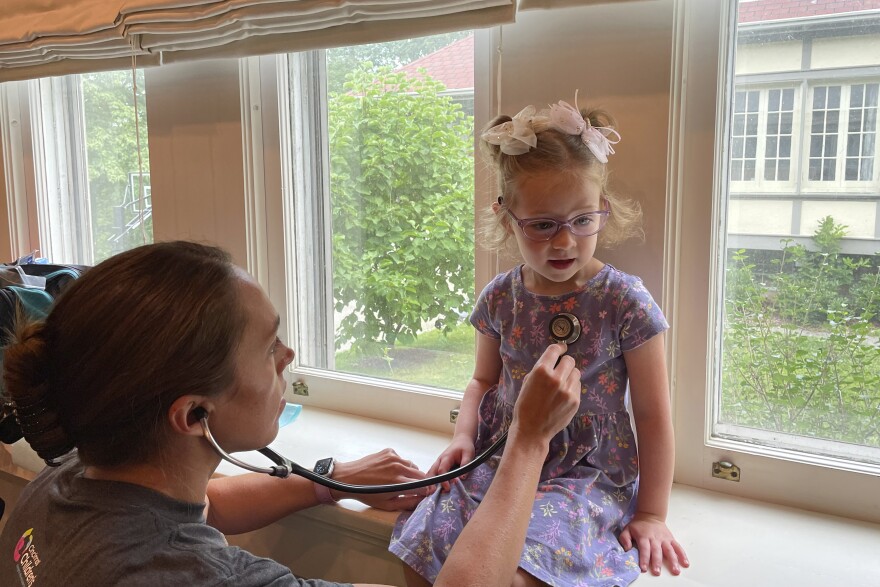 Courtney Chase, a nurse at Cincinnati Children's Hospital Medical Center, listens to 4-year-old Brynn Schulte's heart before the girl gets an infusion of medication to treat a rare genetic bleeding disorder, Aug. 3, 2023, in Cincinnati. Brynn was diagnosed thanks to whole genome testing, which was recently shown to be nearly twice as good at finding genetic disorders in sick babies as more targeted tests. Her parents and doctors credit early diagnosis with saving her life. (AP Photo/Laura Ungar)