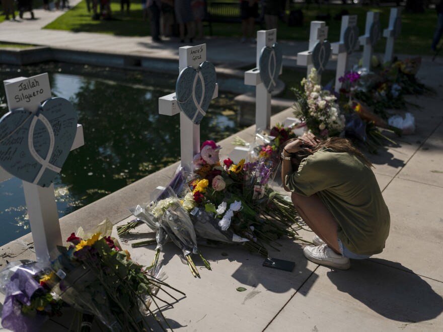 Elena Mendoza, 18, grieves in front of a cross honoring her cousin, Amerie Jo Garza, one of the victims killed in this week's elementary school shooting in Uvalde, Texas, Thursday, May 26, 2022.