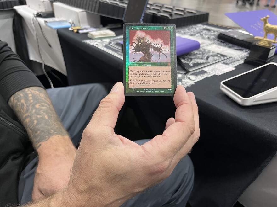 Artists RK Post holds a card he painted.
