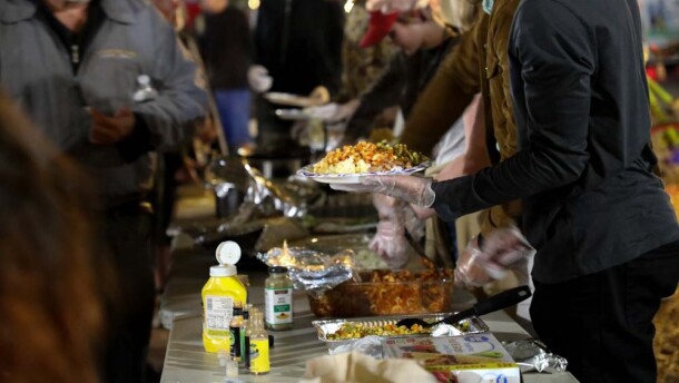 Volunteers serve up food at the Food Not Bombs meal on Friday, Dec. 9.