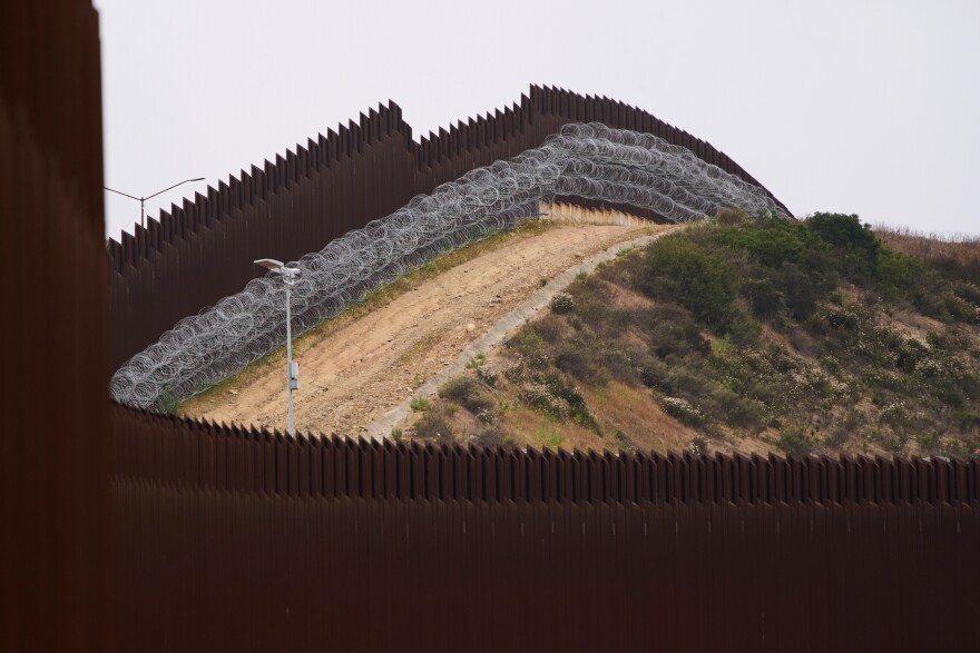 FILE - Concertina wire lines the interior of a border wall separating Tijuana, Mexico, from the United States, June 4, 2025, in San Diego.