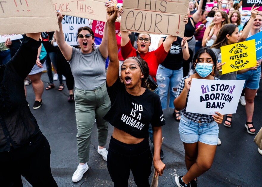 Calvionne Rayford, 29, originally of Kansas City, Mo., throws a fist in the air while demonstrating against a recent Supreme Court decision striking down Roe v. Wade on Friday, June 24, 2022, outside Planned Parenthood in St. Louis. 