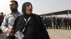 A woman bearing a picture of a relative killed during bloody anti-government demonstrations this year waited outside the Cairo court where former President Hosni Mubarak's trial resumed Monday.