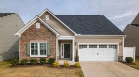 A beige house with landscaping.