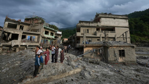 Residents and others look at damaged structures after flash flooding in the Devighat area of the Nuwakot district in Nepal, Friday, Aug. 28, 2026. (AP Photo/Rajesh Kumar Singh)