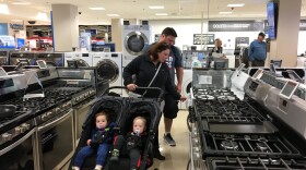 Carla and Jeremy Lang push their twin 18-month-old sons in a stroller while looking at ovens and stoves at a Sears northwest of Chicago.