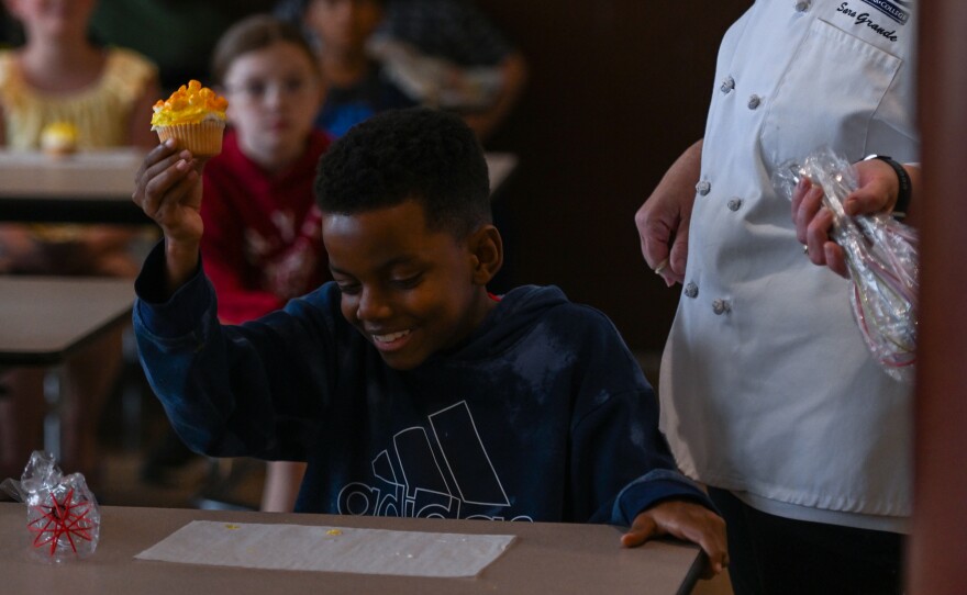 Chance McCulough holds up his cupcake topped with "extra butter."