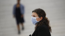 A commuter wears a face mask in the New York City transit system, Monday, March 9, 2020, in New York. New York continued grappling Monday with the new coronavirus, as case numbers, school closings and other consequences grew. (AP Photo/John Minchillo)