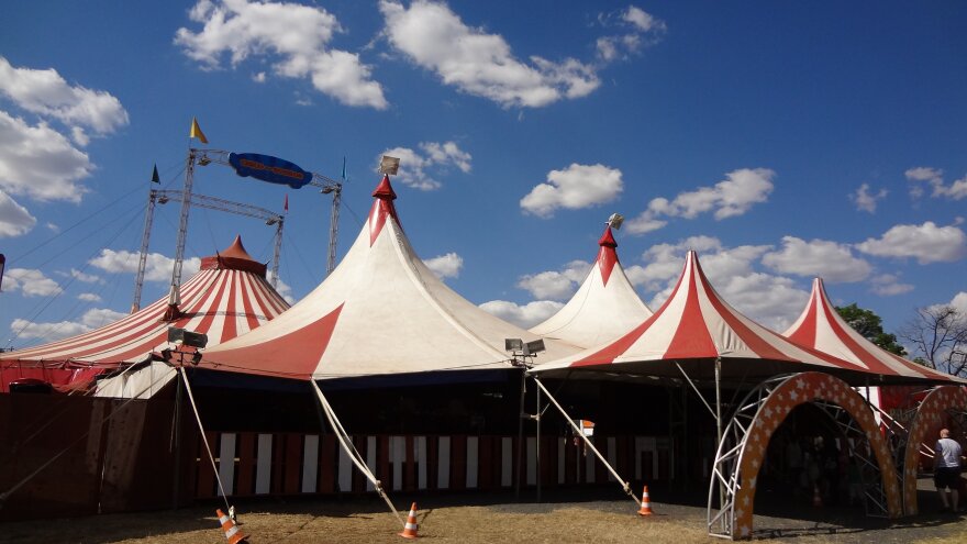 red and white circus tents under a clear summer sky 