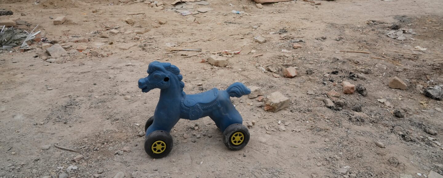 A toy remains on the ground next to a residential building damaged when a nearby police station was hit Friday in a U.S.-Israeli strike in Tehran, Iran, Sunday, March 15, 2026.