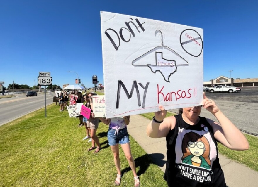 Dozens of people gather in the northwest Kansas town of Hays to protest against the amendment that would remove abortion rights protections from the state constitution. (Photo by David Condos, Kansas News Service)
