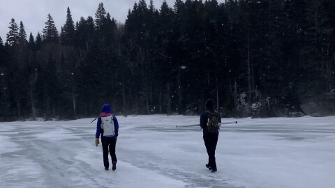 Researchers cross a frozen pond on Saddleback Mountain.