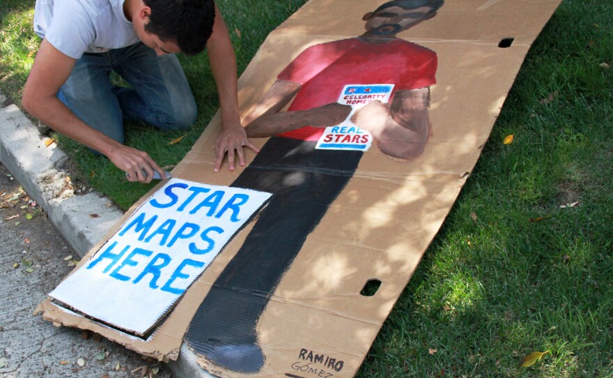 Gomez works on a piece that he later removed after a man selling maps to celebrities' homes threatened to take it down.