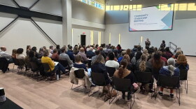 Megan Erskine (standing, center) and Dr. Nirali Bora (standing, right) speak to community and healthcare leaders at a West Michigan Medicaid Task Force briefing.