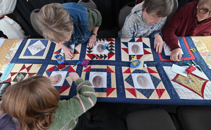 Visitors to the PA Farm Show help make a quilt. Their name will be documented in a book that an auction winner will take home with the finished quilt.