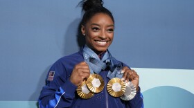 Simone Biles, of the United States, holds up her medals after the women's artistic gymnastics individual apparatus finals Bercy Arena at the 2024 Summer Olympics, Monday, Aug. 5, 2024, in Paris, France. (AP Photo/Charlie Riedel)