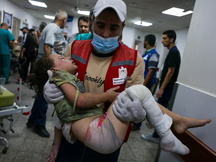 An emergency responder carries a wounded child in a hospital following Israeli airstrikes in Rafah, southern Gaza Strip, on Friday.