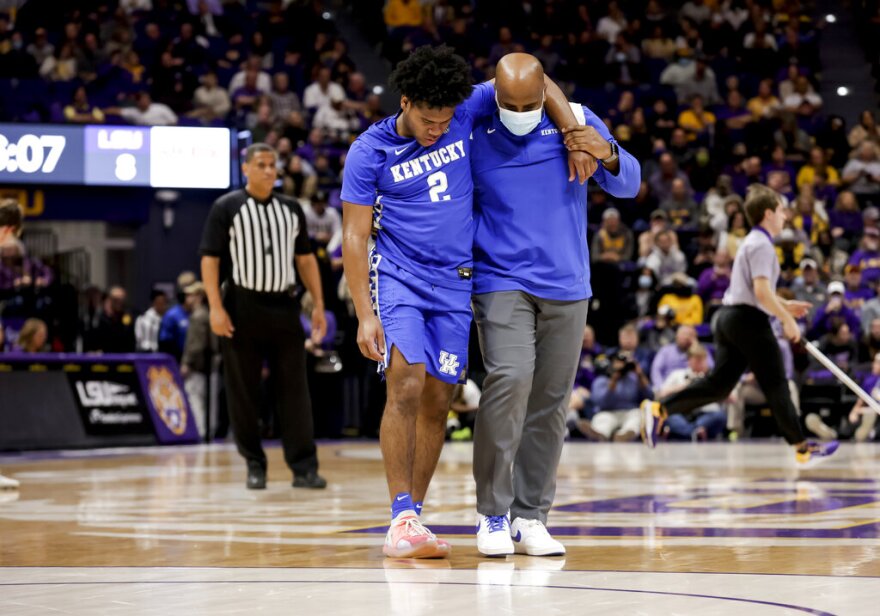 Kentucky guard Sahvir Wheeler (2) is assisted off the court after getting injured in the first half of an NCAA college basketball game against LSU in Baton Rouge, La., Tuesday, Jan. 4, 2022. (AP Photo/Derick Hingle)