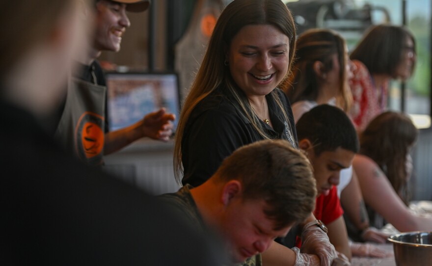 University student Emily Squires jokes while helping make pancake batter.