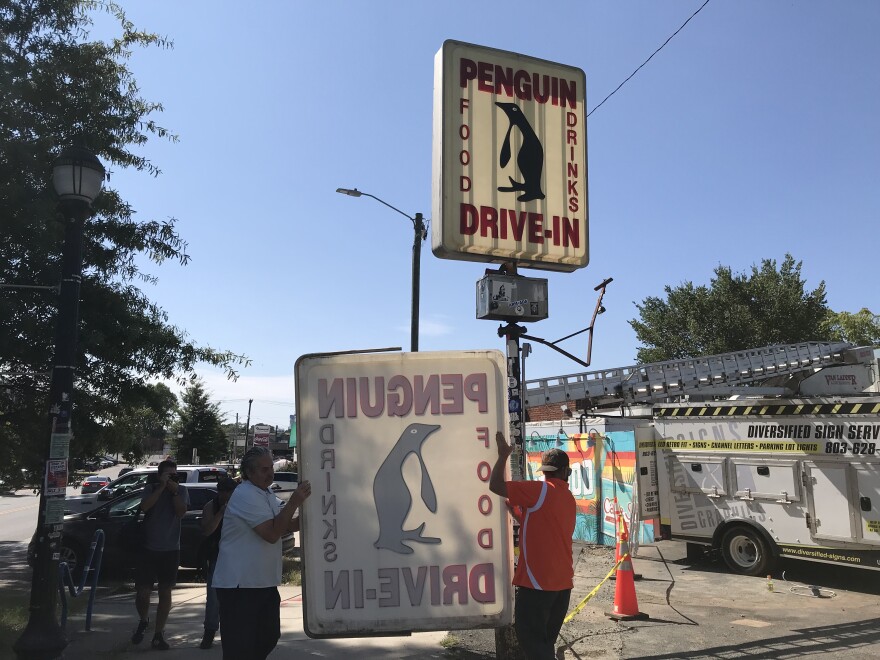 The first of two panels of the Penguin sign is removed Friday.