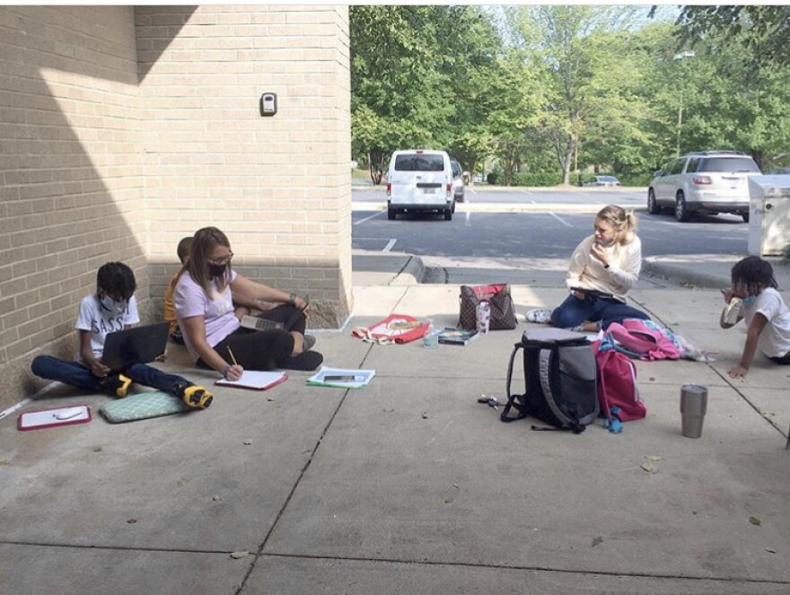 Students work on schoolwork outside the University City Regional Library -- with the help of the library's free Wi-Fi.