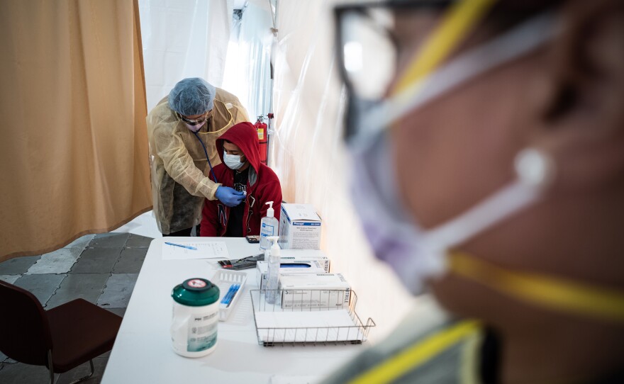 A doctor examines Juan Vasquez as part of a COVID-19 check inside a testing tent outside the emergency department at St. Barnabas Hospital in New York City last week.