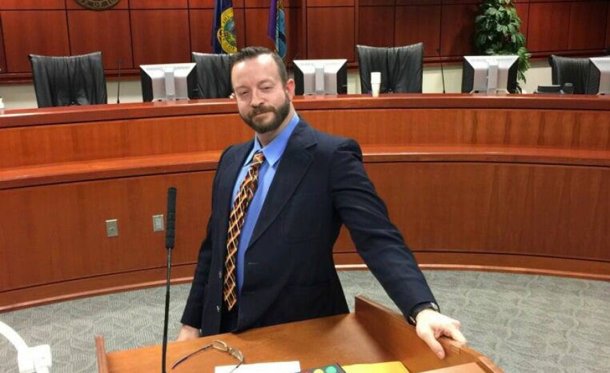 Commissioner Ryan Davidson stands behind a podium in a courtroom.