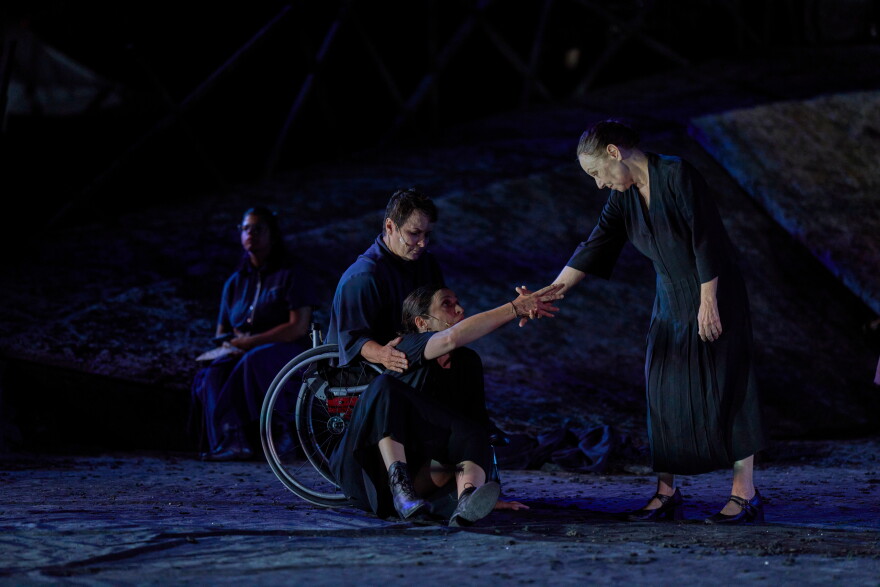 From left to right, Eirini Kourouvani, a wheelchair dancer, Evi Saoulidou and Lydia Fotopoulou perform during a dress rehearsal of Euripides' tragedy The Trojan Women, staged by the National Theatre of Greece, at the Ancient Theater of Epidaurus, Greece, on Thursday, July 30, 2026.