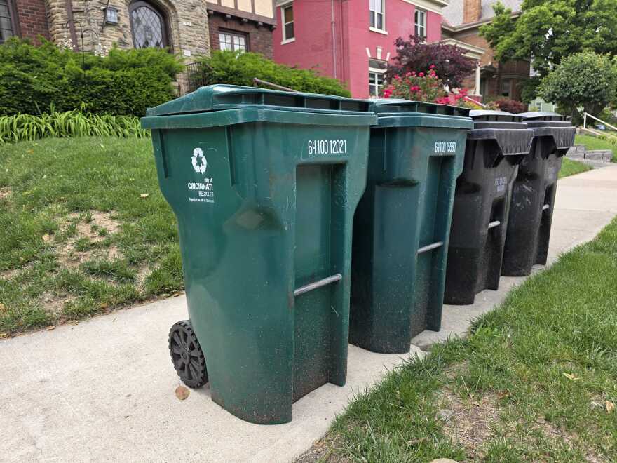 Two curbside recycling carts next to trash cans in Cincinnati's Clifton neighborhood.
