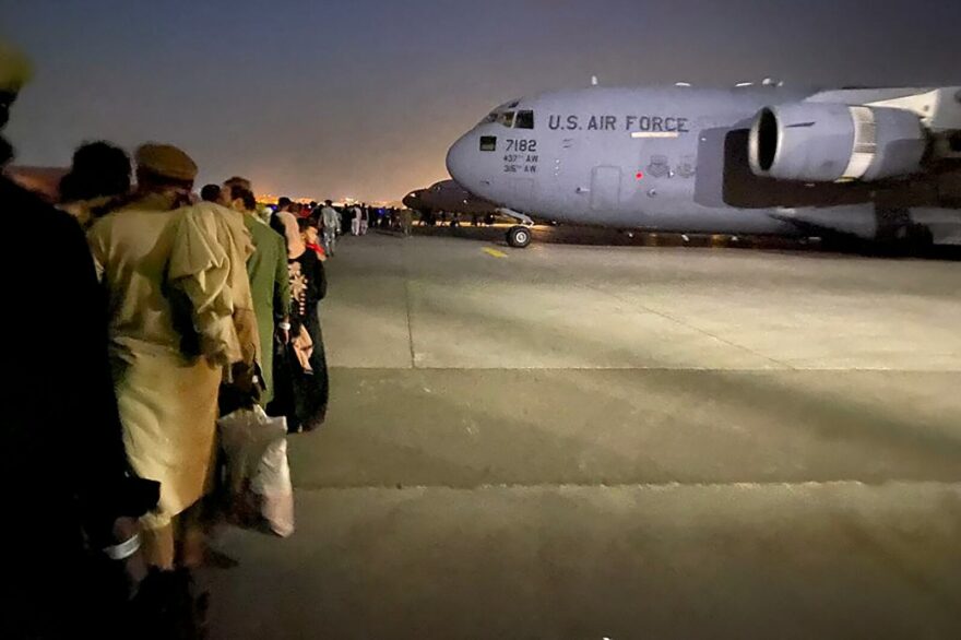 Afghan people queue up and board a U S military aircraft to leave Afghanistan, at the military airport in Kabul after Taliban's military takeover of Afghanistan.