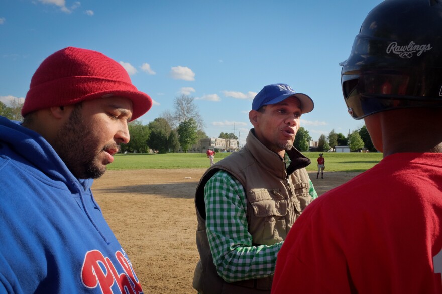 Angel Ramos (left), coach for two of the boys teams, and Bryan Morton (center), president of the league, give a pep talk during a game in Chester, Pa.