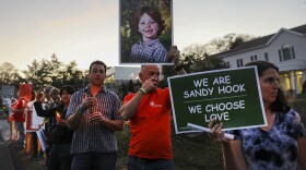 FILE: Mark Barden holds up a picture of his son Daniel who was killed in the Sandy Hook masracre during a vigil remembering the 59 people killed in Sunday's shooting in Las Vegas and calling for action against guns on October 4, 2017 in Newtown, Connecticut.