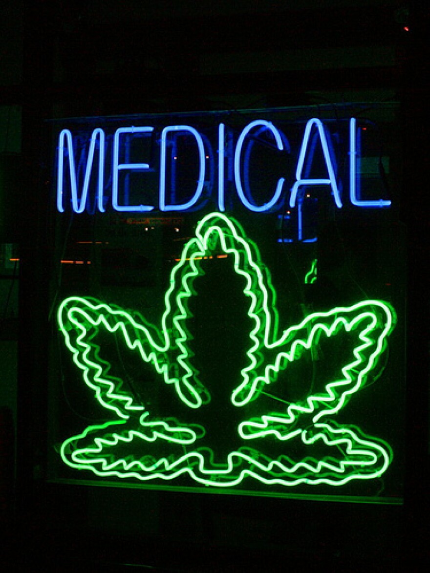 A neon sign reading medical with a marijuana leaf beneath it.