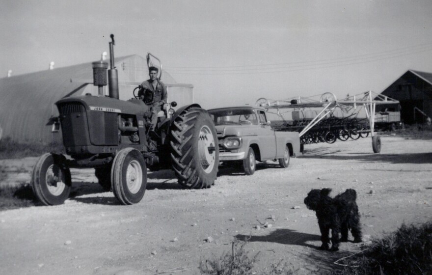 A black and white photo shows Marvin Farr on a tractor early in his farming career.