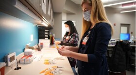 Nurses prepare the first dose of the Moderna COVID-19 vaccine at the OSF vaccination clinic in Peoria in this February 2021 file photo.