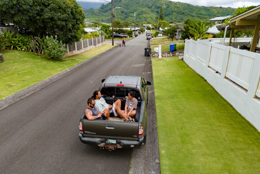 An image of locals in the bed of a pickup truck in Kailua, Hawaiʻi.