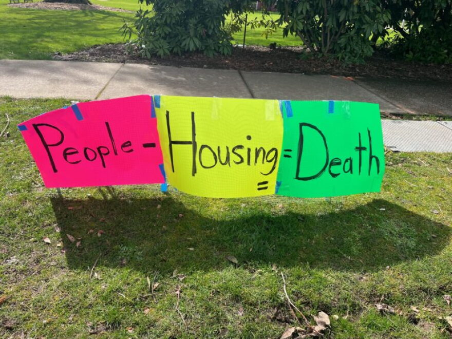 Neon posters across from the Oregon Capitol seek to remind legislators that homelessness kills.
