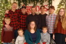 10 members of a family posed in front of a Christmas tree