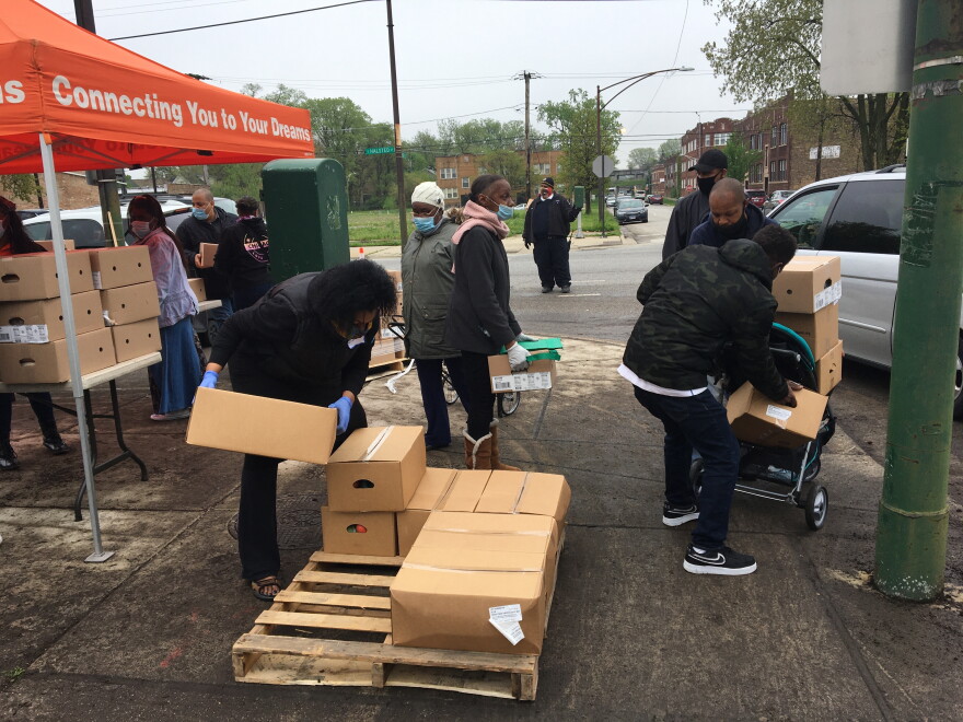 Residents of the Auburn-Gresham neighborhood line up for boxes of food at a weekly pop-up food pantry.