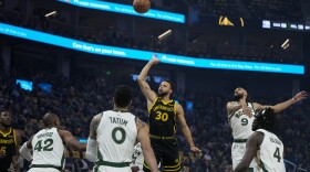 Golden State Warriors guard Stephen Curry (30) shoots next to Boston Celtics guard Derrick White (9) during the first half of an NBA basketball game Tuesday, Dec. 19, 2023, in San Francisco. (AP Photo/Godofredo A. Vásquez)
