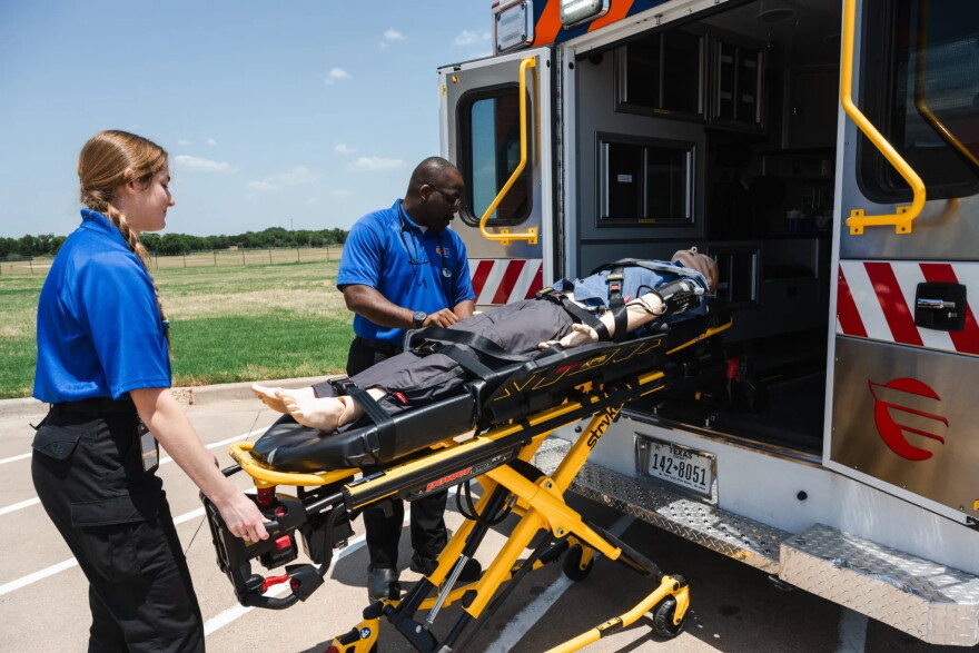McLennan Community College paramedicine students Adrianna Marcovecchio and Smith Owens wheel a medical training mannikin into an ambulance on July 22