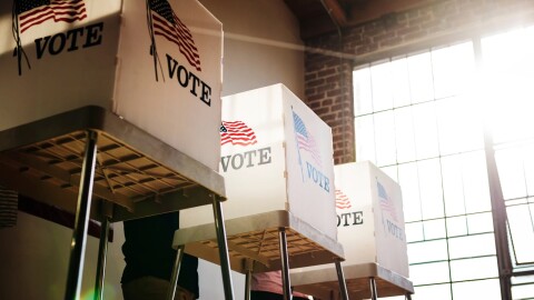 Three voting booths in use during an election.