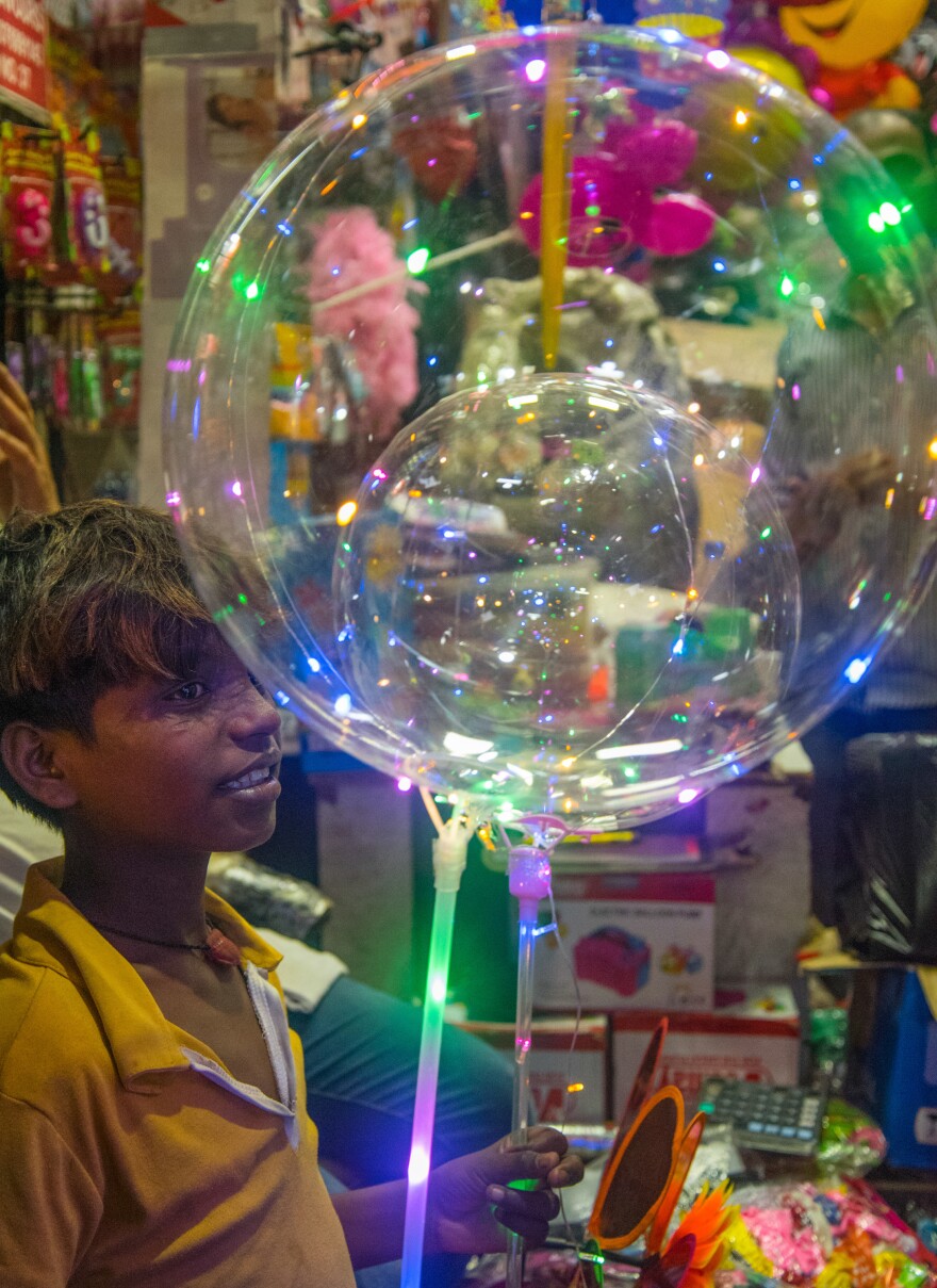 Jitender, 12, and his mother, Barkha, took a two-day train trip from her home state of Assam to New Delhi to buy 500 LED balloons to sell on the street.