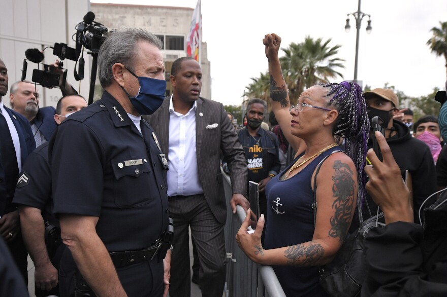 Los Angeles Police Department Chief Michel Moore speaks to a protester after a vigil with members of professional associations and the interfaith community at LAPD headquarters, Friday, June 5, 2020, in Los Angeles.
