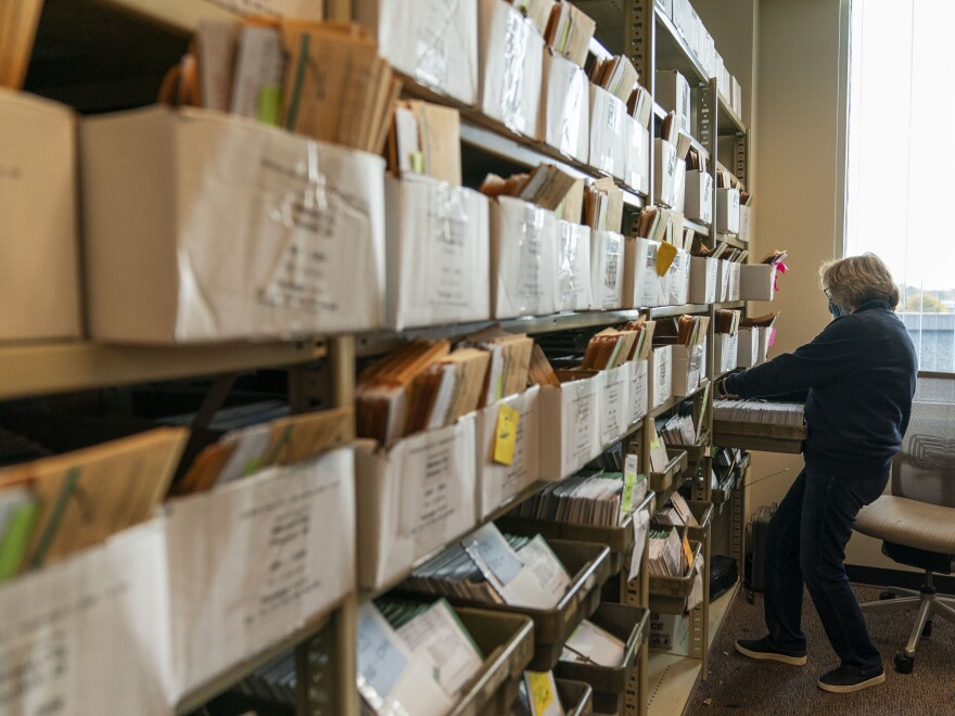 An election worker organizes absentee ballots ahead of Election Day at the city clerk office in Warren, Mich.