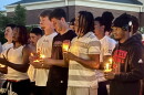 William Jewell football players hold candles during the vigil for MichaJo Barnett.