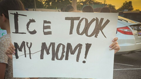 A child protests the ICE arrest of 121 people from a restaurant in Memphis on Aug. 31.